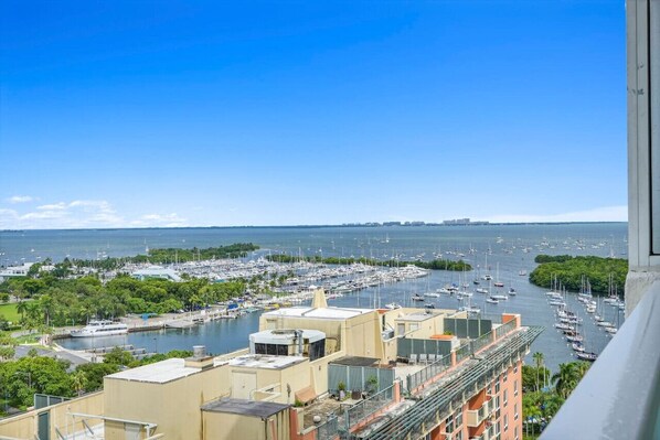 A marina with numerous boats docked, surrounded by buildings and greenery.