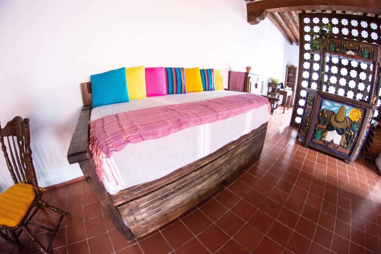 Quarto com cama, cadeira e decoração na parede.