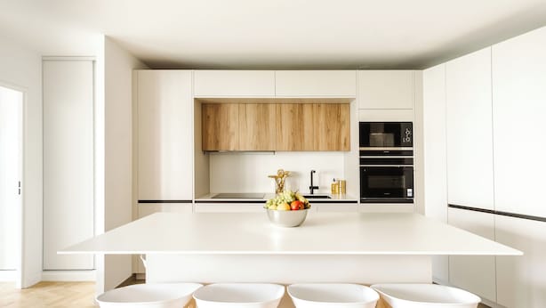 A modern kitchen with a large island, white cabinetry, and a wooden accent wall. - Appart. Victoria(sleeps 7, 2 parking spaces)- Les Demoiselles à Versailles (Versailles)