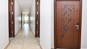 Un pasillo con una puerta de madera marcada con el número 207, que da a una habitaci ón.