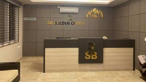 Una mesa de recepción con un cartel que dice "SB GOLDEN CHERRY" y un logotipo encima.