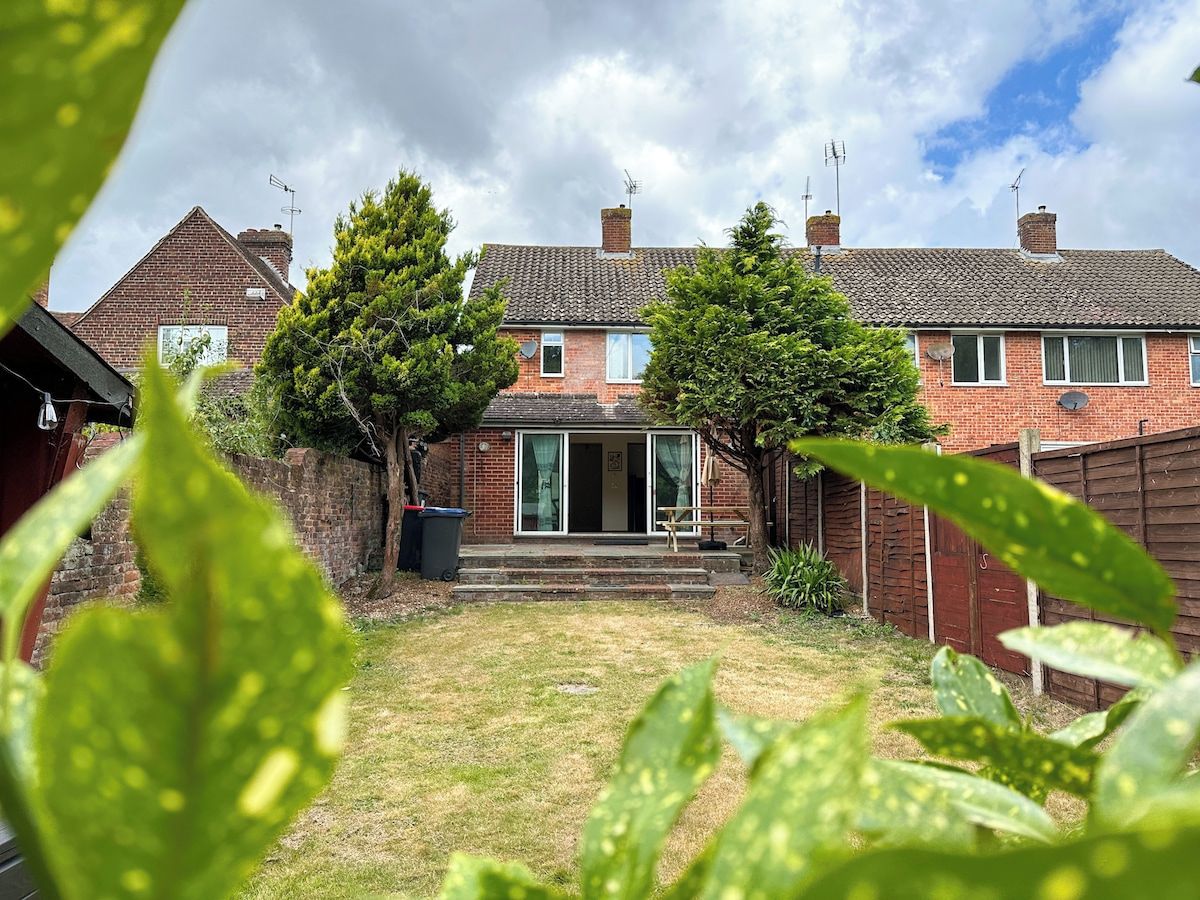 A residential property with a brick facade, a front door, and a small front yard.