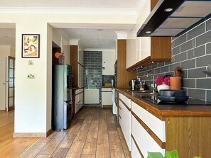 Eine moderne Küche mit einer Holzausziehtheke, einem eingebauten Ofen und einer gefliesten Spritzschutzwand.