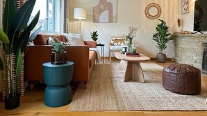 A cozy living room with a sofa, a coffee table, and a fireplace. - NEW The 82 | Spacious 3 Bed House on the River (Canterbury)