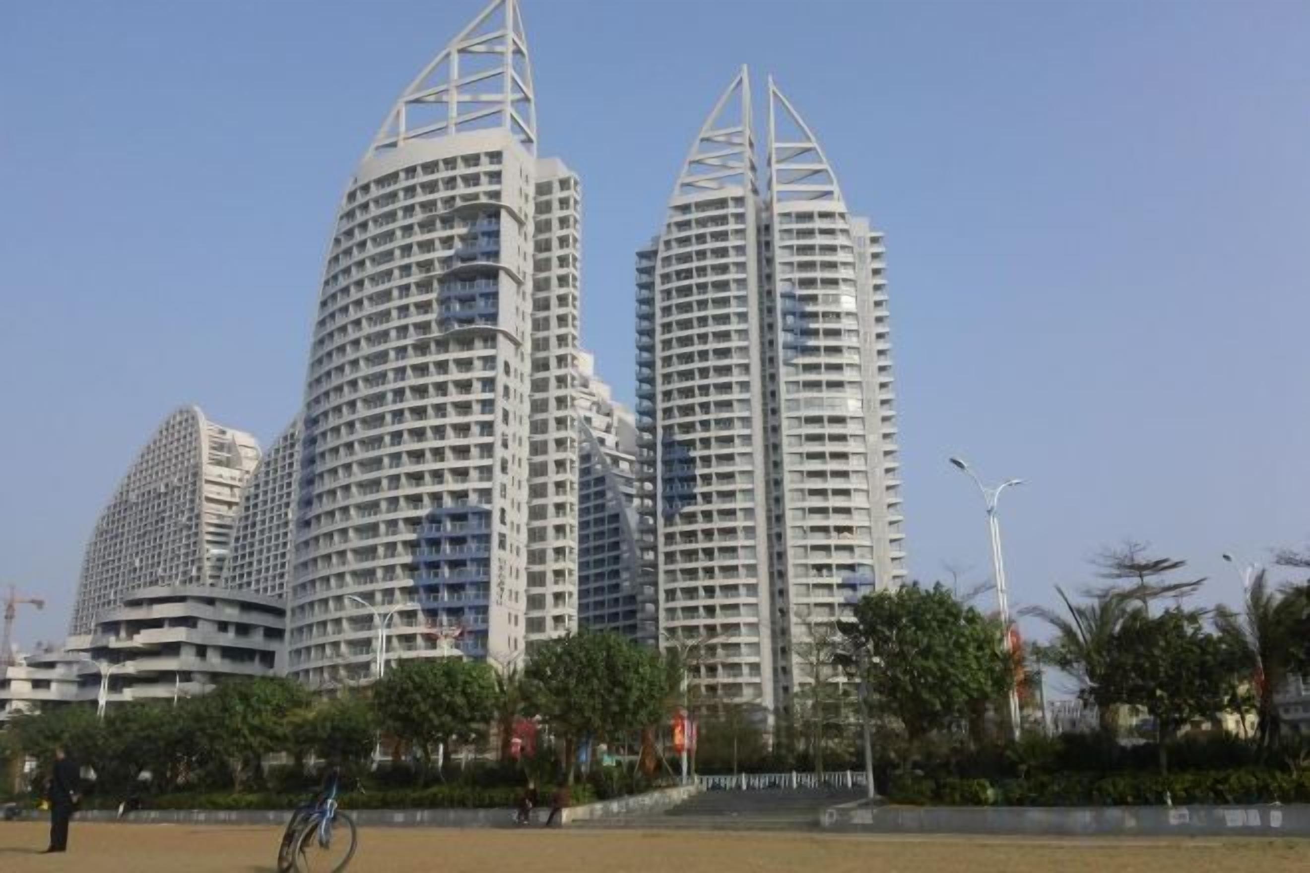 A modern building with a unique architectural design, featuring multiple floors and a distinctive curved structure.
