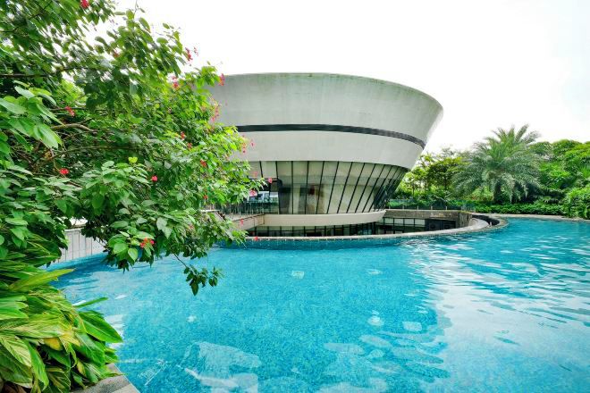 A swimming pool with a modern building in the background.