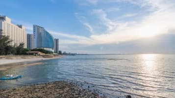 A coastal view with buildings, a beach, and calm waters.