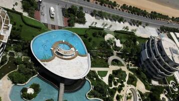 A large building with a circular central courtyard, surrounded by landscaped areas and a road.