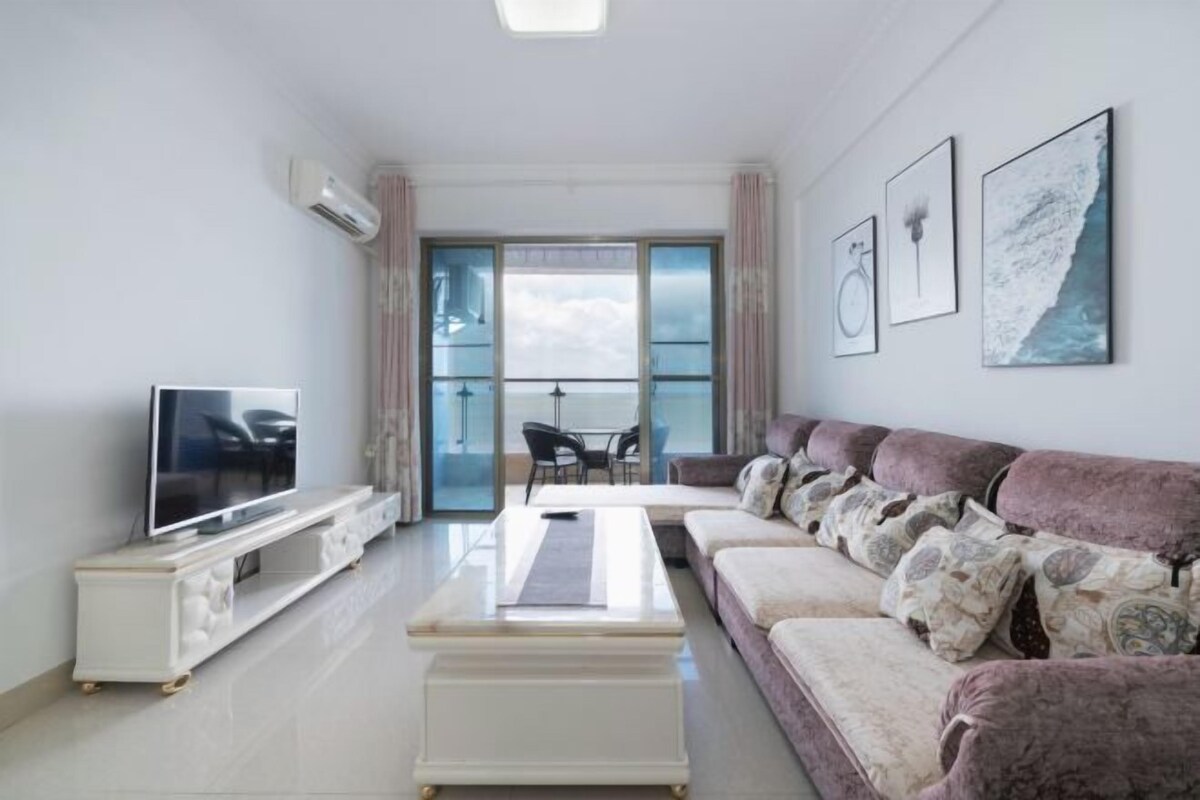 Ein modernes Wohnzimmer mit Fernseher, Sofa und einem Kunstwerk an der Wand.