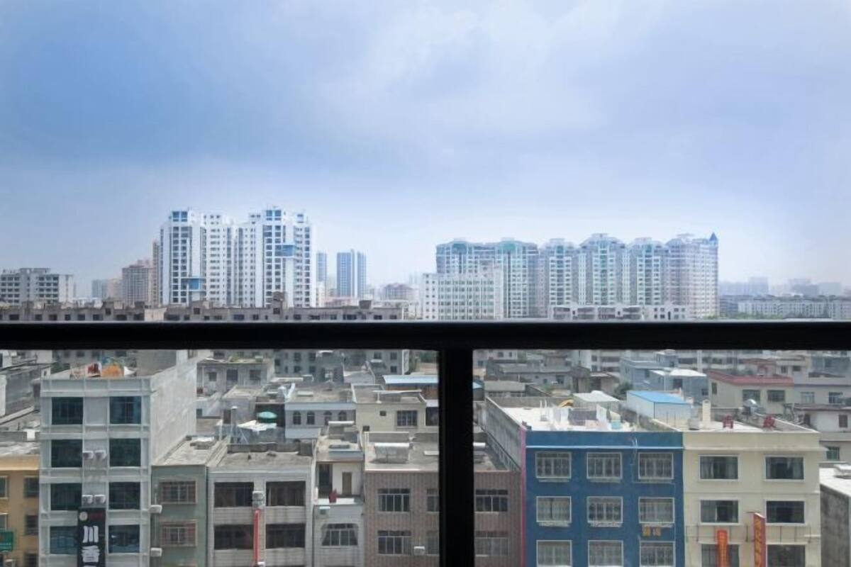 A cityscape viewed through a window with multiple high-rise buildings in the background.