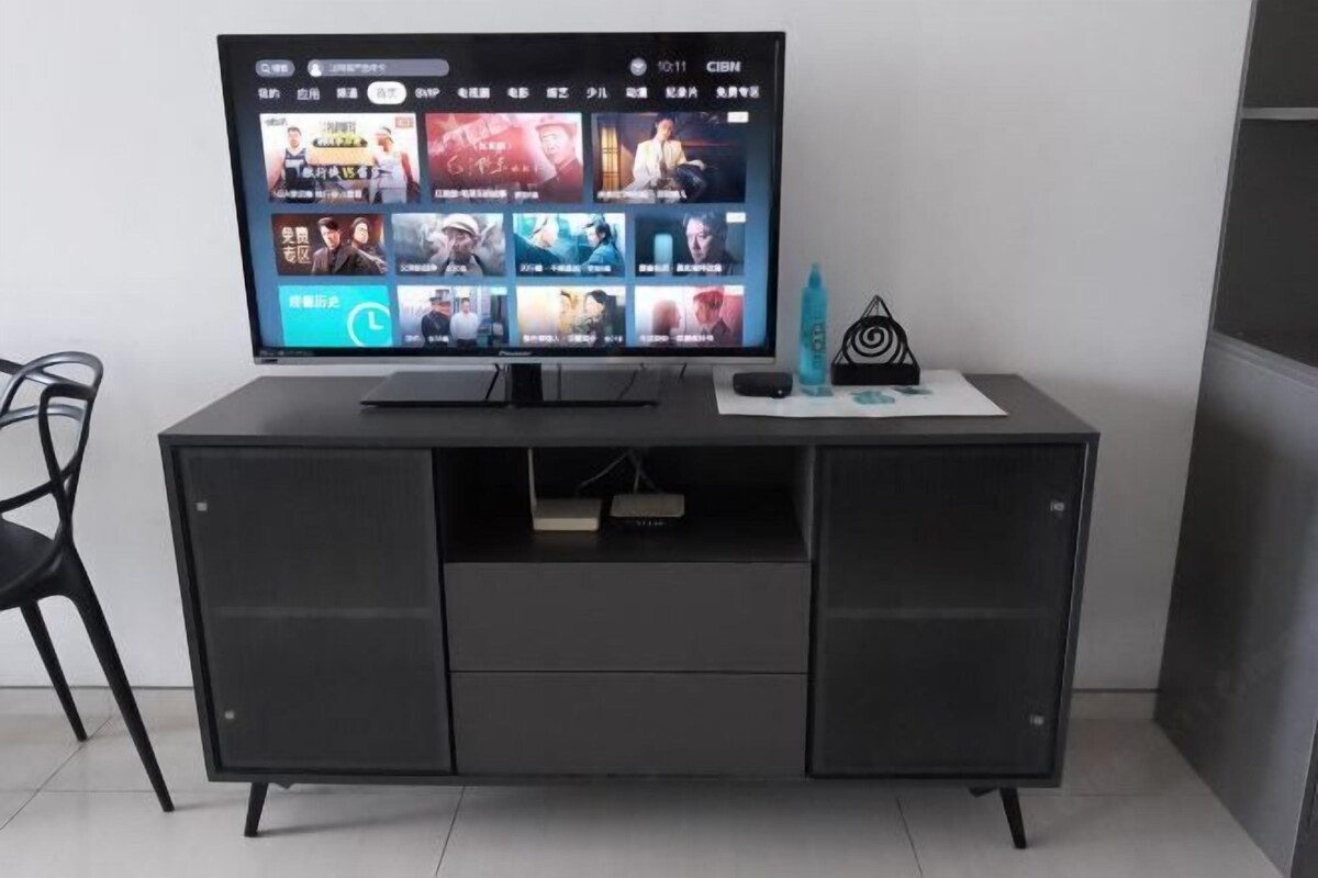 Eine moderne Unterhaltungsanlage mit einem Flachbildfernseher, der eine Streaming-Dienstanwendung zeigt.