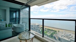 A modern bathroom with a glass-enclosed shower, a bathtub, and a glass table. - Beihai Tuyu Oceanfront Scenic Apartment (Beihai)