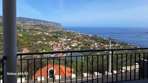 A balcony with a view of a coastal town, houses, and the sea. - Figueira's House by the Atlantic (Ponta do Sol)