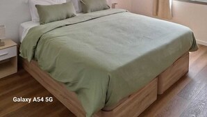 A bedroom with a bed, a nightstand, a window with curtains, and a ceiling light. - Figueira's House by the Atlantic (Ponta do Sol)