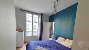 A bedroom with a bed, a nightstand, a window, and a door. - Saint Honoré - Luxury Apartement 1 BR (Paris)