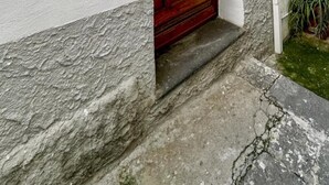 Un bâtiment rustique avec une porte en bois et un petit porche.