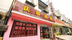 A building with a red and yellow sign indicating a hotel. - Xuancheng Qinglin Hotel (Xuancheng)