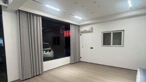 A room with a large window, a door, a ceiling light, and an air conditioning unit. - Xuancheng Qinglin Hotel (Xuancheng)