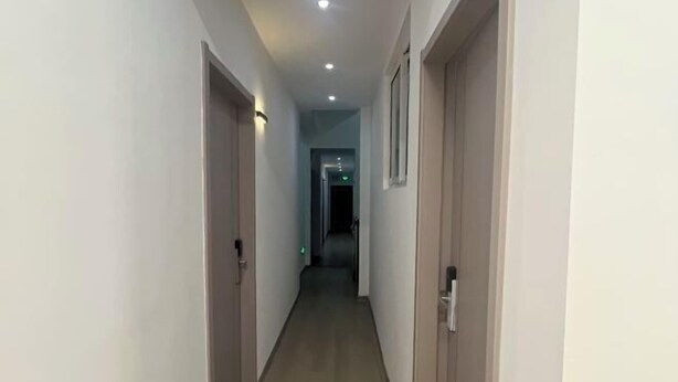 A hallway with doors on both sides, a light-colored floor, and recessed ceiling lighting. - Xuancheng Qinglin Hotel (Xuancheng)