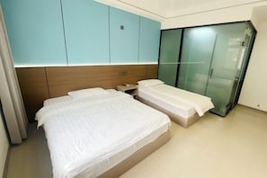 Ein Hotelzimmer mit zwei Betten, einem Kleiderschrank und einem Schiebetürenschrank.