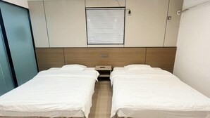A twin room with two single beds, a small bedside table, a window with blinds, and a wall-mounted air conditioning unit. - Xuancheng Qinglin Hotel (Xuancheng)