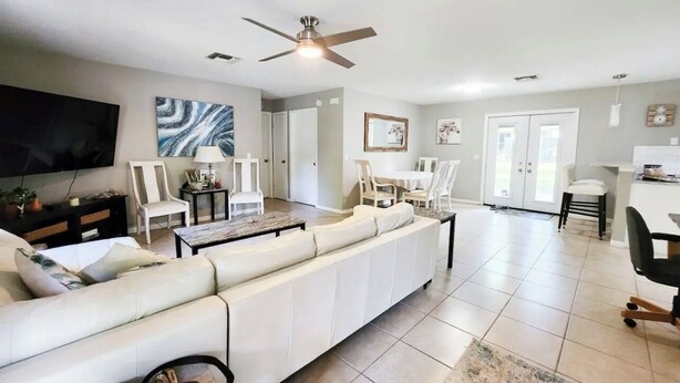 A spacious living room with a large white sofa, a flat-screen TV, and a ceiling fan. - 3-bedroom house in charming Ocala with AC, WiFi.
Located in the heart of Ocala  (Ocala)