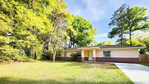 A single-story house with a front porch, a well-maintained lawn, and a wooden fence. - 3-bedroom house in charming Ocala with AC, WiFi.
Located in the heart of Ocala  (Ocala)