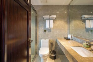 A modern bathroom with a toilet, bidet, and a large mirror. There are towels hanging on a rack and a trash bin on the floor. - Yuting Hotel (Wenzhou)