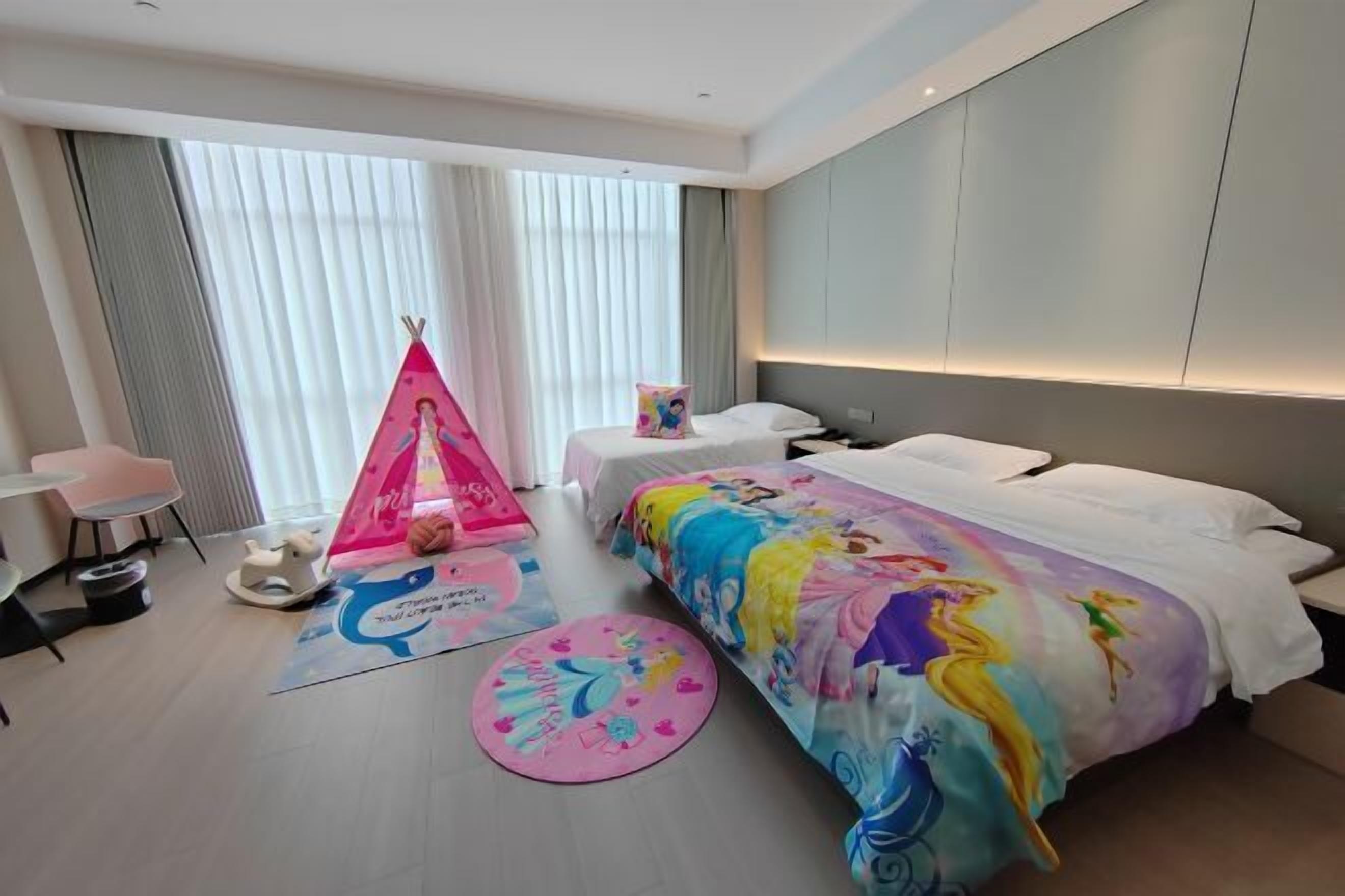 A hotel room with a large bed, a small desk, a chair, a tent, and a window with curtains.