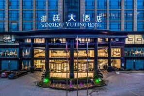 The exterior of Wenzhou Yuting Hotel with a prominent entrance and a well-lit facade. - Yuting Hotel (Wenzhou)