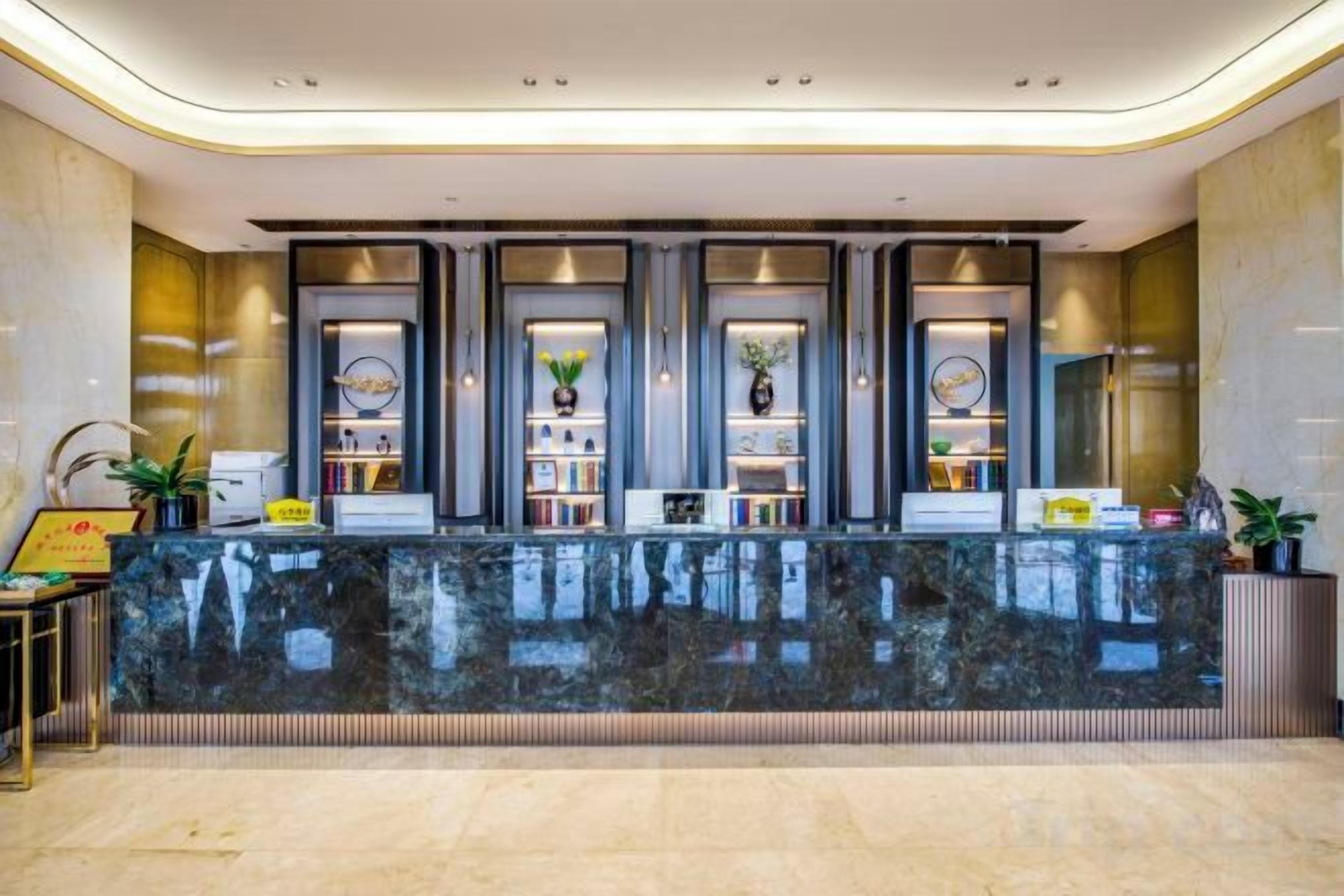 A reception area with a marble counter, bookshelves, and framed certificates.