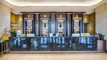 A reception area with a marble counter, bookshelves, and framed certificates.