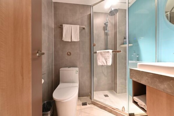 A modern bathroom with a glass shower enclosure, a toilet, and a vanity with a mirror. - Homeinn Hotel (Beijing Shaoyaoju University of International Business and Economics) (Beijing)