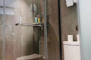 A glass-enclosed shower area with a toilet visible to the right. - Homeinn Hotel (Beijing Shaoyaoju University of International Business and Economics) (Beijing)