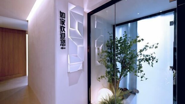 A modern interior with a glass partition, a potted plant, and a wall-mounted shelf. - Homeinn Hotel (Beijing Shaoyaoju University of International Business and Economics) (Beijing)
