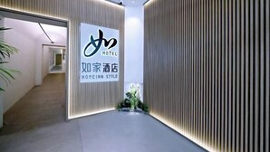 A hotel interior with a modern design, featuring a reception area with a signboard displaying the hotel name and a minimalist decor with vertical wooden panels. - Homeinn Hotel (Beijing Shaoyaoju University of International Business and Economics) (Beijing)