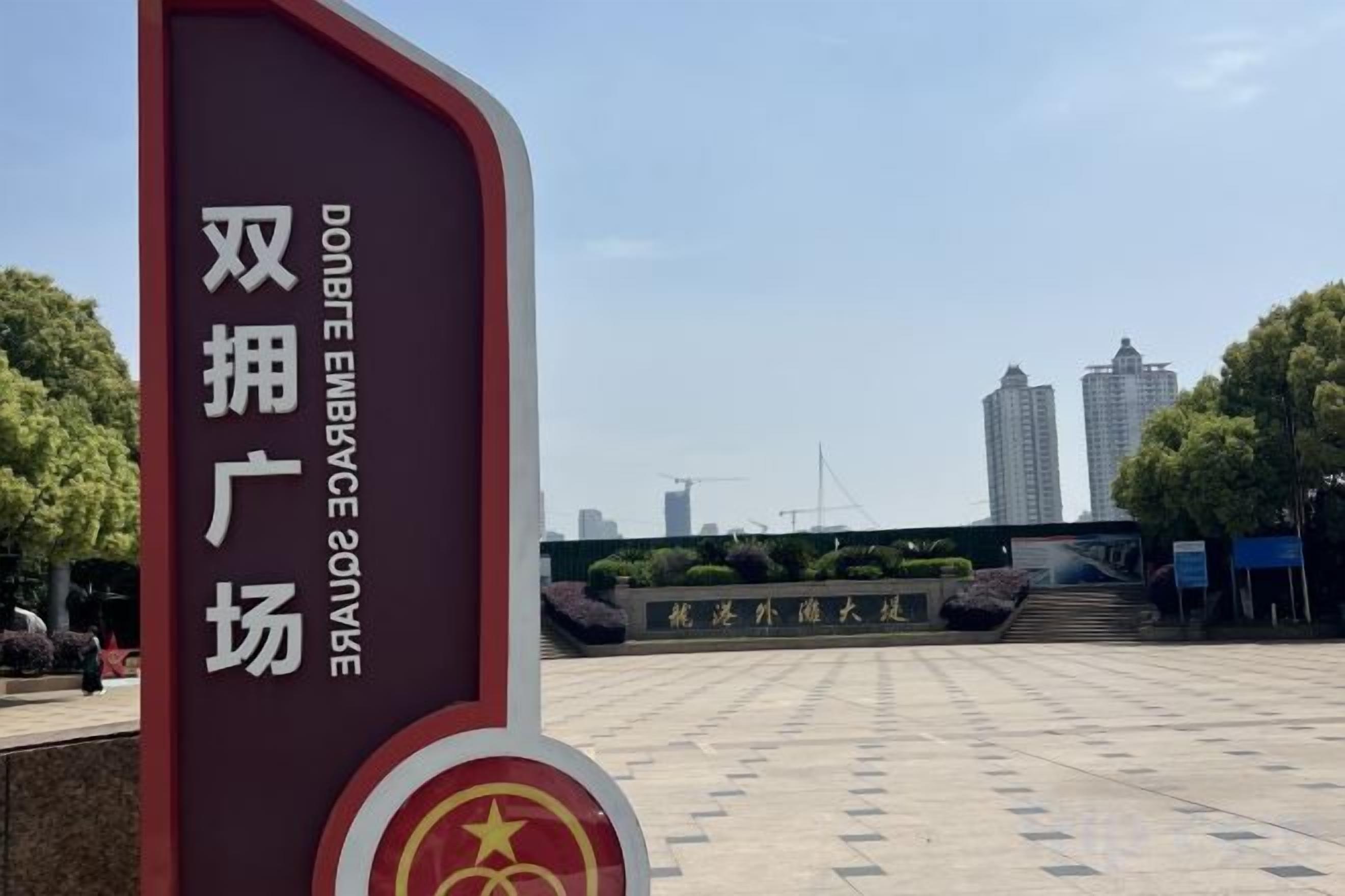 A sign with Chinese characters and a red emblem, indicating a location.