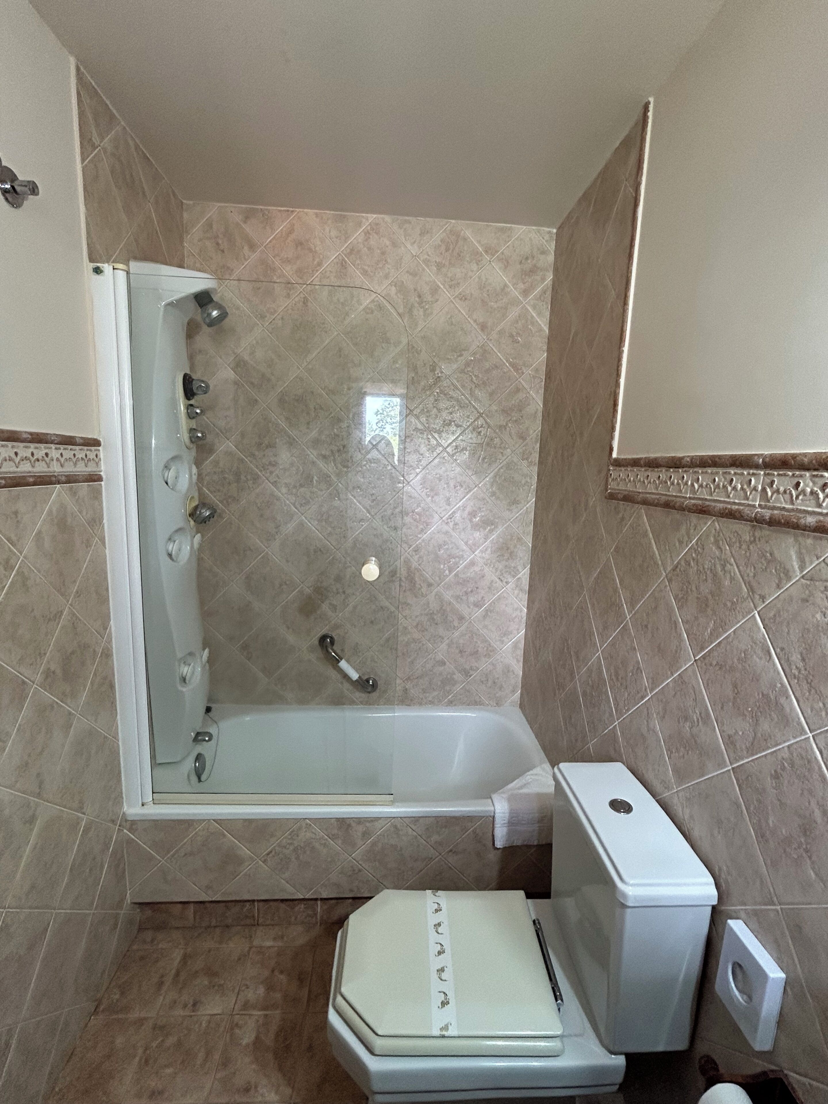 Un baño con bañera, inodoro y ducha.