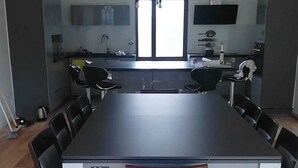 A modern kitchen with a large island, dark countertops, and a pendant light. - Beautiful country house located in Eure-et-Loire in an idyllic setting (La Bazoche Gouet)
