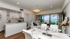 Ein modernes Wohnzimmer mit Essbereich, einer Küche und einem Balkon mit Blick.