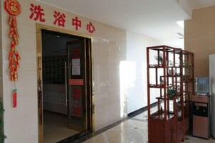 Entrada de hotel con un cartel que dice '洗浴中心' (centro de baño).