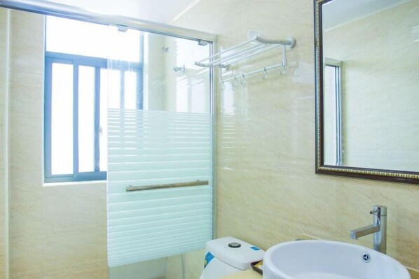 A bathroom with a toilet, sink, and a mirror. - Caiyuan Bihai Yuntian Hotel (Shengsi)