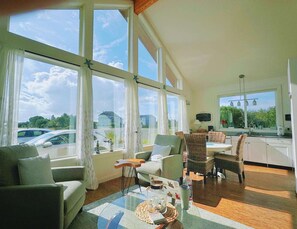 A spacious living room with large windows, a dining area, and a kitchen. - Ocean Shore Private Lovely house (Ocean Shores)