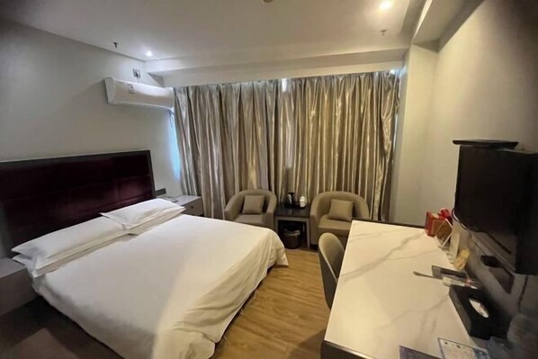 A hotel room with a bed, a desk, a chair, a TV, and a curtain. - Fuerte Hotel Yueqing Jianqiao (Yueqing)