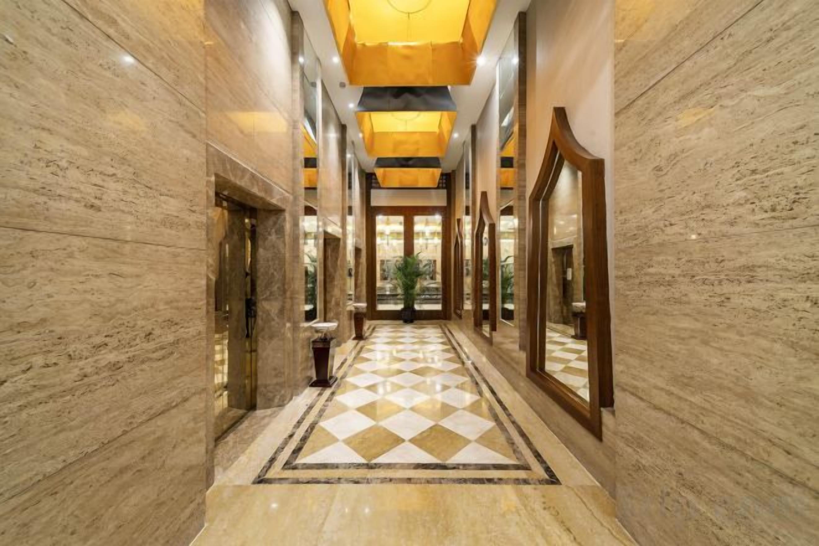 A hallway with a checkered floor, marble walls, and a central light fixture.