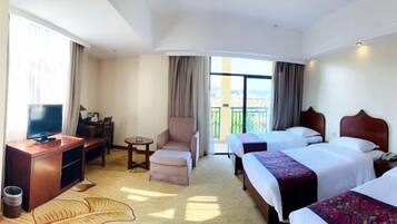 A hotel room with two beds, a TV, a desk, and a chair.
