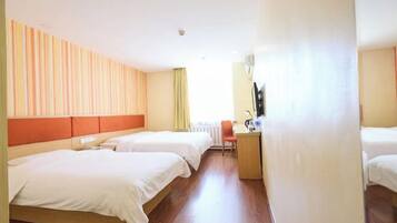 A hotel room with two beds, a desk, and a window.