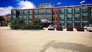 A multi-story building with a parking lot in front.