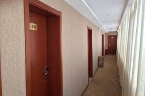A hotel corridor with doors marked with room numbers, carpeted flooring, and a plain wall. - Anning IKEA Express Hotel (Anning)