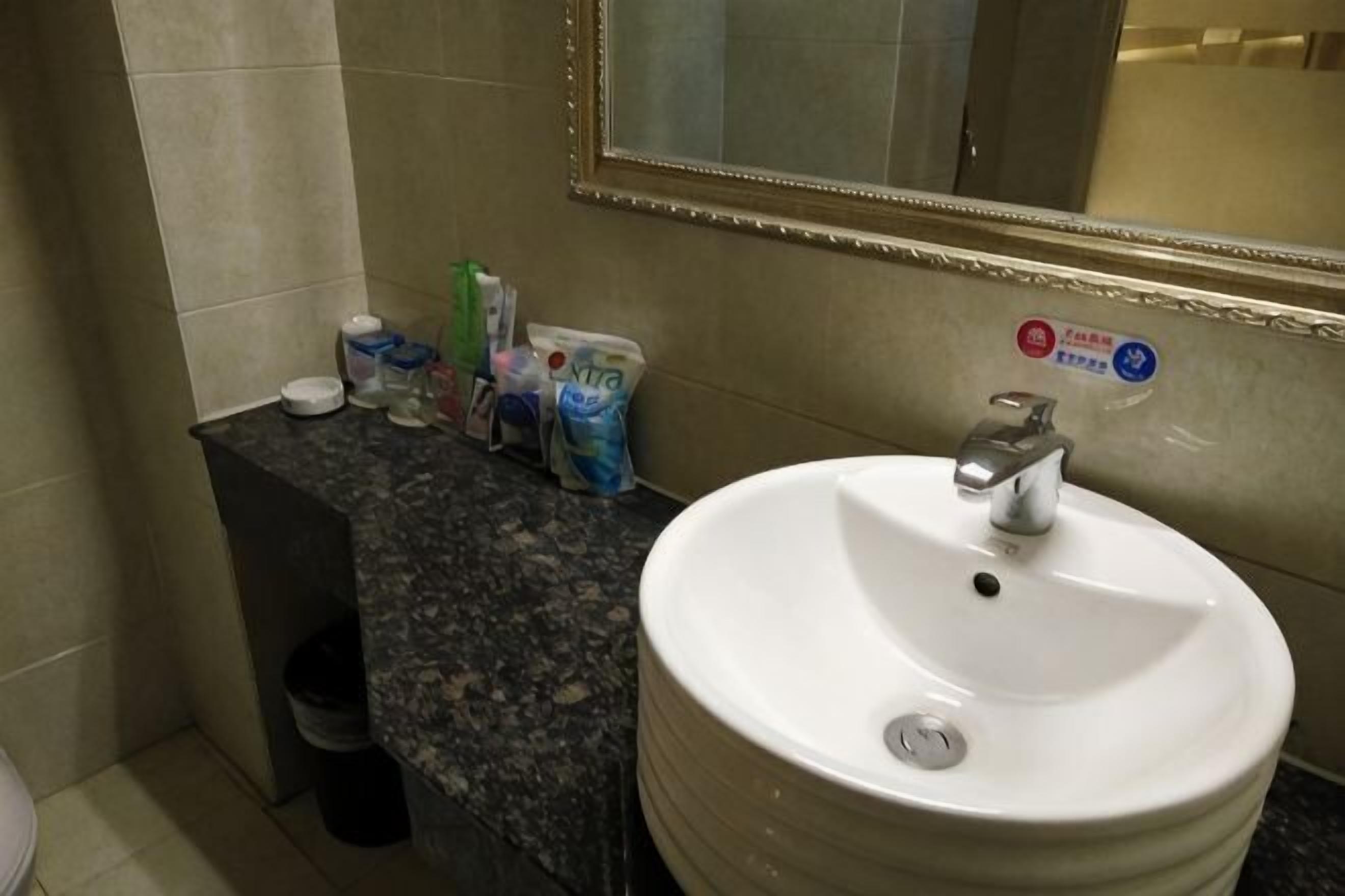 Une salle de bain équipée d’un lavabo, d’un miroir et d’articles de toilette.